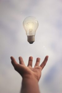 light bulb floating above a hand. idea in motion